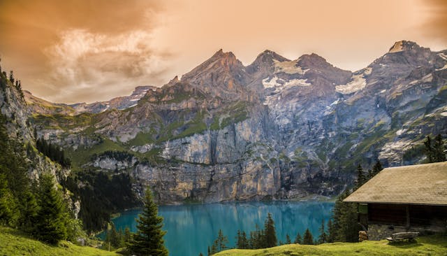 A scenic view of mountains during sunset with a lake in the foreground